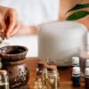 Essential Oils bottles on table along with person hand opening bottle